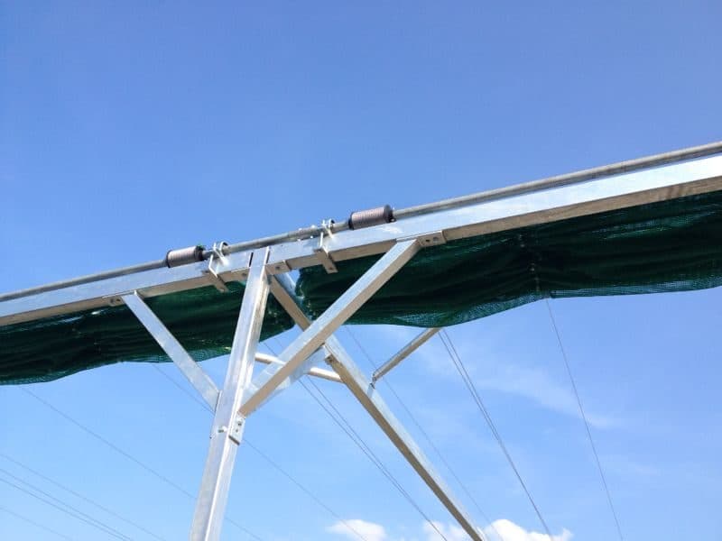 Wspornik zadaszenia z siatką cieniującą na tle nieba