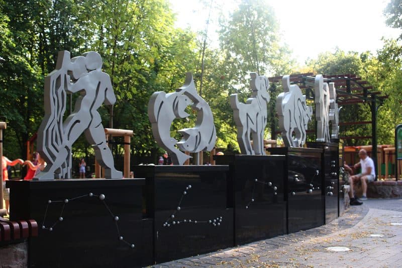 Stalowe rzeźby figur na czarnych cokołach